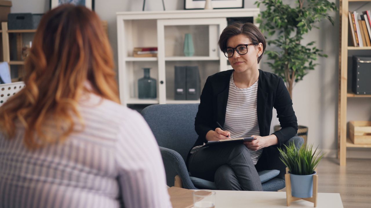 Mastering the First Impression: Your intriguing post title goes here A therapist and patient having a counseling session in a modern office sitting area.